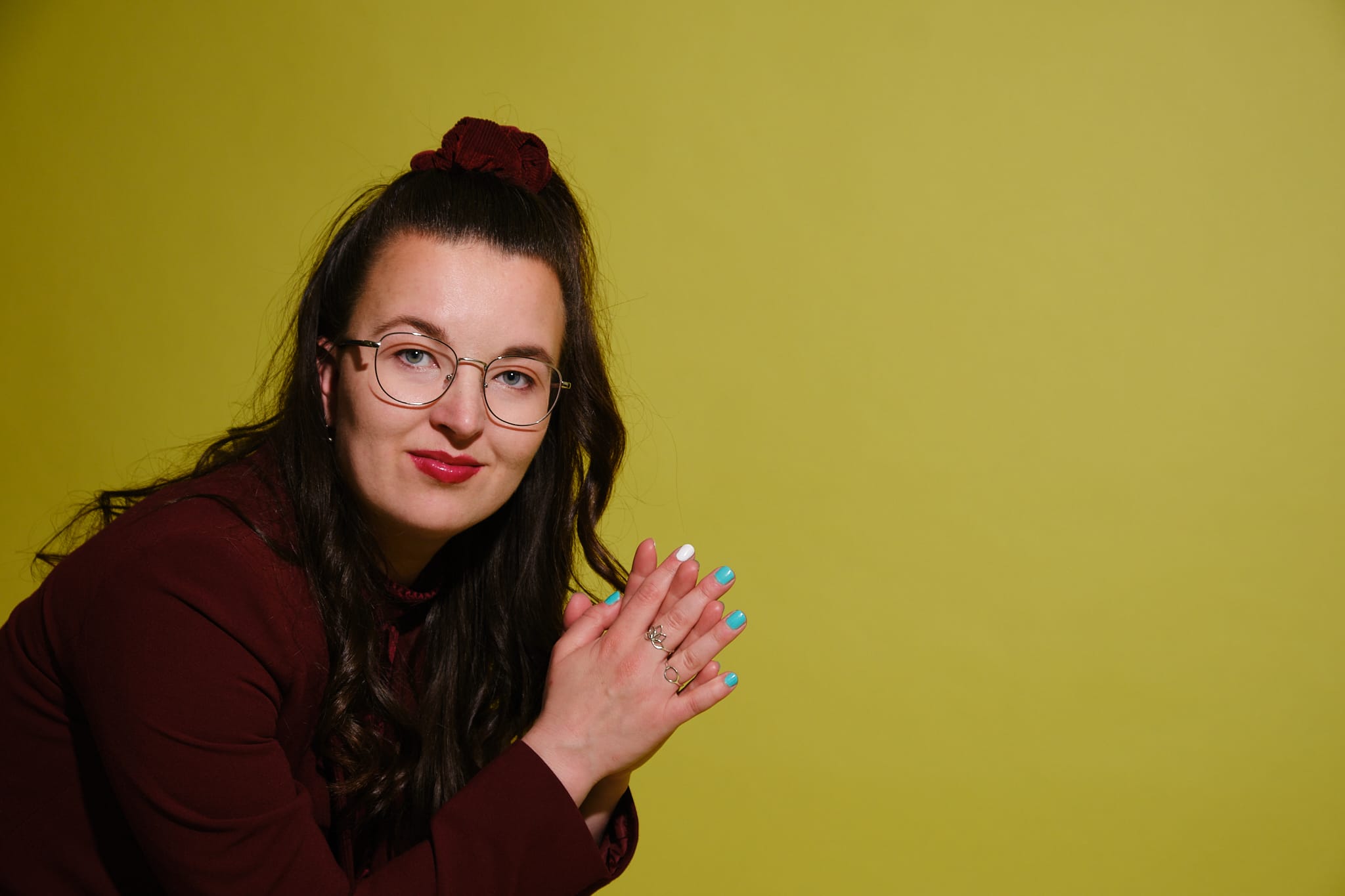 Foto van Marieke van Ik snap M informatiedesign in rood pak voor gele achtergrond.