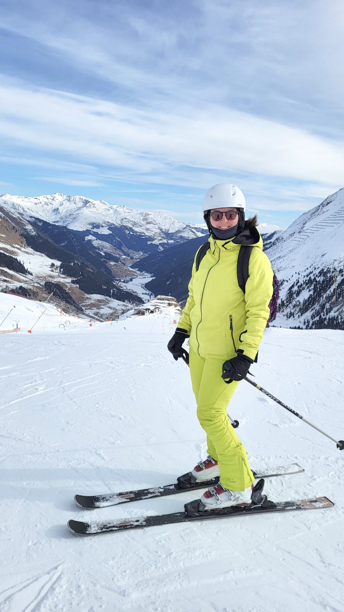 Foto van Marieke in lichtgeel skipak op een berg op de ski's